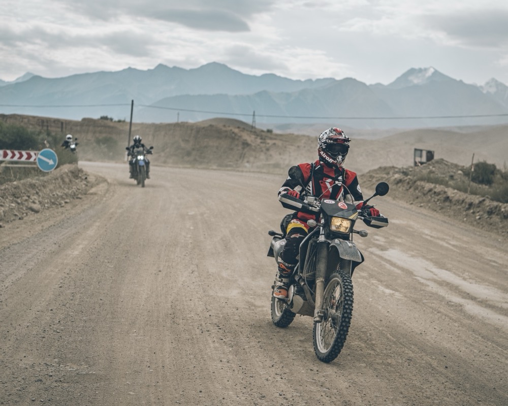 Own motorcycle on a gravel road in Kyrgyzstan